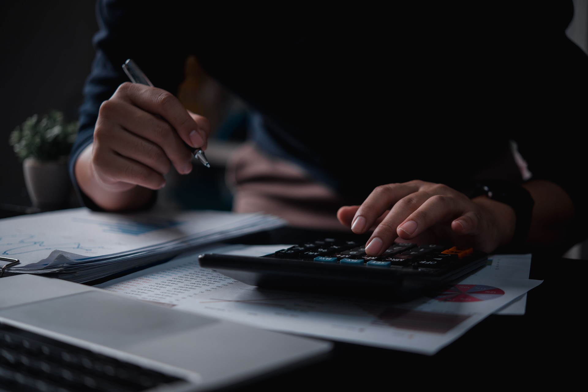 Businessman using calculator bookkeeping payroll and budget tax. Business document finance accounting investment